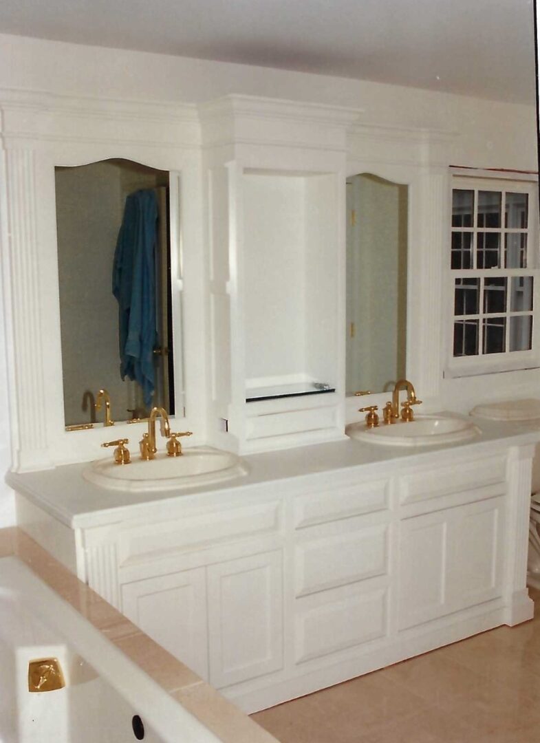 a bathroom countertop with two sinks and wall-mounted mirror