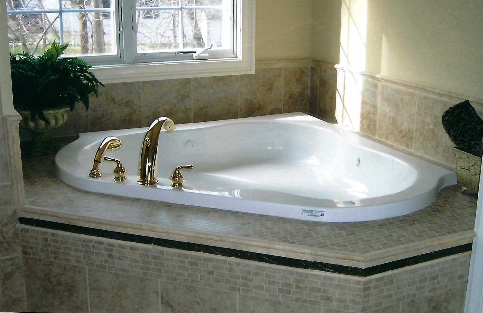 a tub deck with a vase of ferns