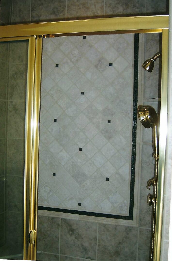 a shower enclosure with golden frame