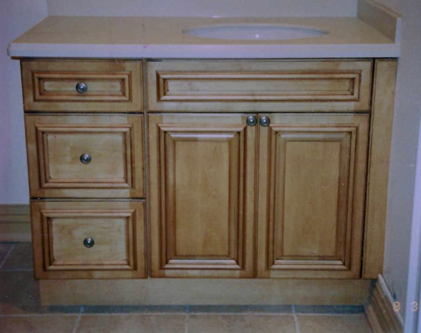 wash area with wooden drawers and cabinets